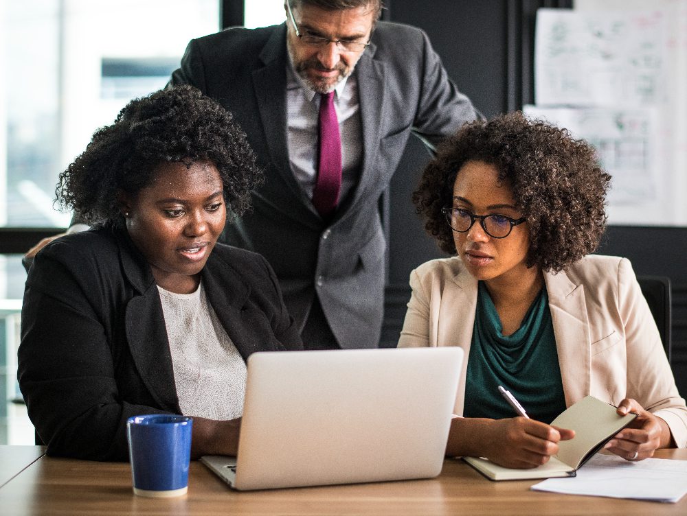 Multiracial analyst team use BI Fintech software to analyze financial data on meeting table. Financial dashboard data display on laptop screen with analyzed chart for marketing indication.